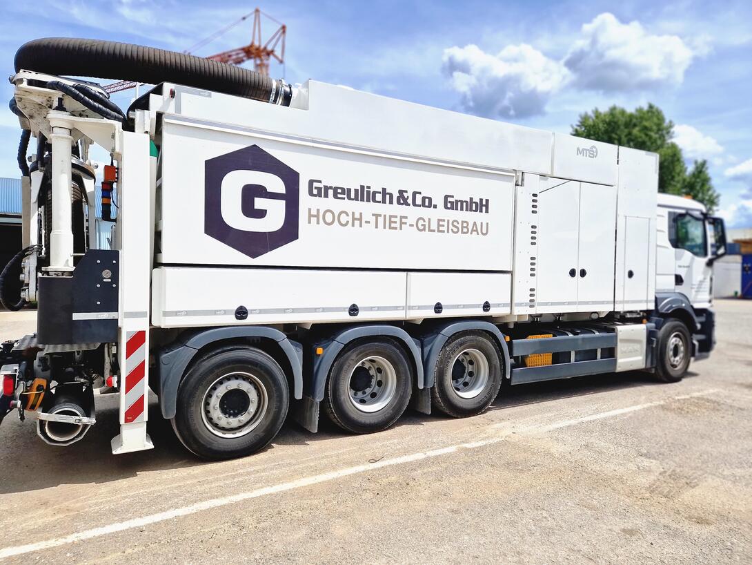Saugbagger und LKW im Einsatz auf einer Baustelle